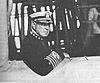 photograph of Rodman in the service uniform of an admiral, leaning against a railing during a fleet review in 1919.