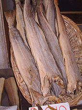 Photo of several dried fish suspended head-down