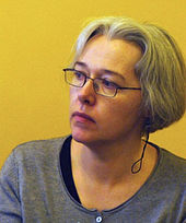 Photograph of a woman with short gray hair and glasses.