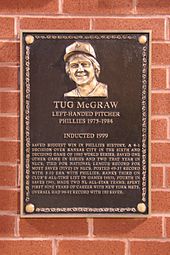 A bronze-and-black plaque of a smiling, shaggy-haired man; the primary caption reads "Tug McGraw"