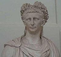 Marble torso of Claudius wearing a wreath and robe (pinned to the front of his right shoulder).