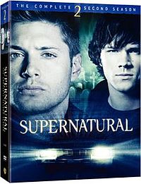 A DVD box set with the cover featuring close-up shots of the faces of two men, with a graveyard in the backgrand and the headlights of an automobile in the foreground.