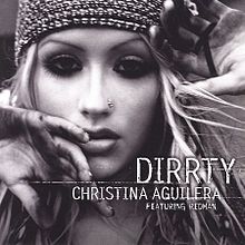 Picture with the words "DIRRTY CHRISTINA AGUILERA FEATURING REDMAN" under the image of a Blonde woman's face. She has a nose earring, a tight fitting cap, and mascara-darkened eyes. Her hands are partially blocking the view of her face.