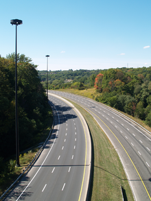An empty six lane highway in a forested valley