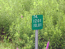 Close-up of a small green sign depicting a set of numbers.
