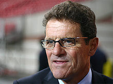 A head-shot of a brown-haired man in his sixties. He has blue eyes and is wearing glasses.