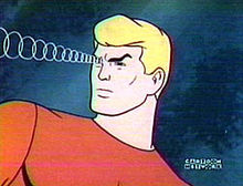 Aquaman is shown concentrating and looking over his right shoulder. Concentric rings are shown coming from his forehead as a special effect related to his telepathic control of fish.
