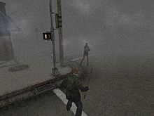 A screenshot from a video game. On a the corner of a foggy street, a monster with no arms faces a man in a green jacket wielding a pipe.