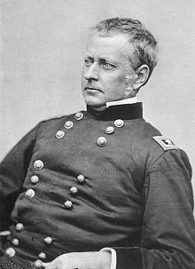 Historic photograph of the head and torso of a man in American Civil War uniform.  He appears to be seated and is looking off to the right.  He is clean shaven, with short gray hair.  His expression is stern.