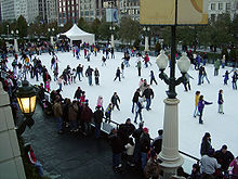 An ice skating rink with dozens of skaters