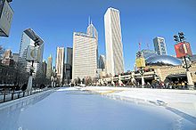 An empty ice skating rink with tall buildings in the background