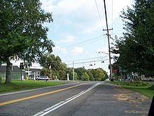 A pair of highways meet at a signalized intersection in a residential neighborhood.