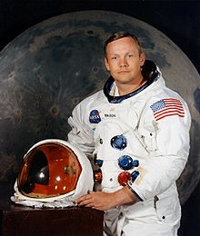 Photo of Neil Armstrong, posing in a space suit with the helmet off.