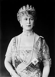 Lady in tiara and gown wearing a choker necklace and a string of pearls