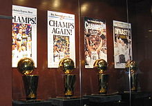 Four trophies on display behind a glassed wall
