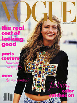 November 1988 cover of American Vogue magazine, showing model Michaela Bercu, shot from just below the waist in natural outdoor light, wearing a $10,000 jewel-encrusted Christian LaCroix T-shirt with faded 450 jeans. The top headline on the cover reads "The real cost of looking good"
