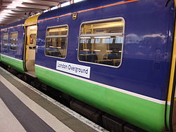 an old unit in purple and green design with a London Overground sticker
