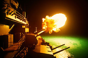 A Mark 7 16-inch/50 caliber gun is fired aboard the battleship USS Missouri (BB-63) as night shelling of Iraqi targets takes place along the northern Kuwaiti coast during Operation Desert Storm.