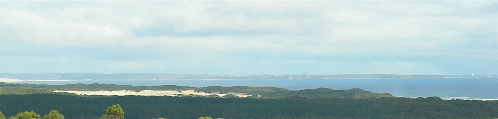 Cape Sorell lighthouse on right, Ocean beach at left and behind sandhills in foreground