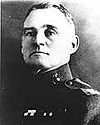 Head and shoulder of man with jutting jaw in circa 1920 U.S. Marine uniform.