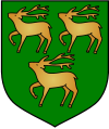  A shield displaying a coat of arms. A green background with three white stags (two above one) facing left, with their front right feet raised