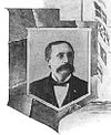Head and shoulders of an otherwise-cleancut man with an enormous mustache, in circa-1900 formal dress.