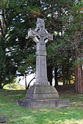 Stone Celtic Cross with circular accent around intersection in cross. Celtic knots decorate the length of the cross.