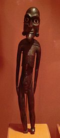 a colour photo of a thin male statuette in dark brown wood