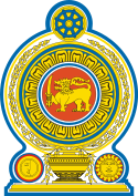 Coat of arms of Sri Lanka, showing a lion holding a sword in its right forepaw surrounded by a ring made from blue lotus petals which is placed on top of a grain vase sprouting rice grains to encircle it. A Dharmacakra is on the top while a sun and moon are at the bottom on each side of the vase.