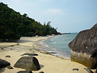 Shoreline of a beach in Pulau Tioman(Tioman Island) with large boulders at the water edge and a mangrove.
