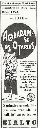 Movie poster featuring an illustration of a goateed man wearing a straw hat, plaid shirt, short polka-dotted tie, short pants, and boots. The accompanying text is in Portuguese.
