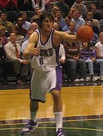 Andrew Bogut lunges toward a rebound while playing for the NBA's Milwaukee Bucks.