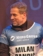 Bandić smiling and looking to his right, wearing blue-and-white skiing jersey over brown long-sleeved shirt