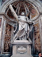 This statue shows an elderly man, bare-chested, and draped, looking up despairingly as he supports a large cross, arranged diagonally.