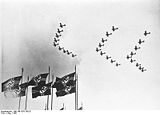 Three lines of aircraft fly in arrow formation