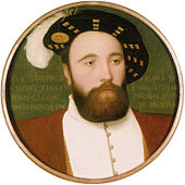 A man with a thick, full beard and a calm expression wearing a doublet jacket and a wide-brimmed hat