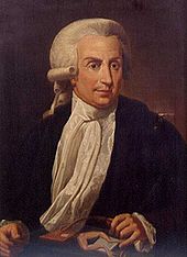 Painting of a middle-aged man sitting by the table, wearing a wig, black jacket, white shirt and white scarf.