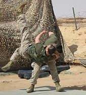 color photo of a Marine tossing another Marine over his shoulder onto a mat