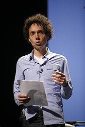 A man holds a piece of paper while he gives a speech.
