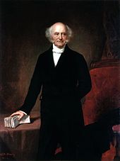 A three-quarters length painted portrait of a balding man with gray hair, standing with his right hand grasping a bundle of papers lying on a table