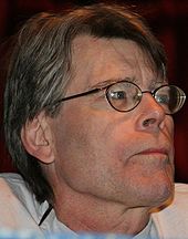 Close up of a short-haired man wearing glasses.