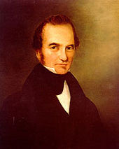 Portrait of a man with receding hairline and long sideburns, wearing an 1840s-style suit.