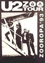 A black poster with a black-and-white image occupying most it. The image shows U2 walking up the stairs of a small airplane as Bono gives a peace sign towards the viewer. Text on the poster reads "U2 Zoo TV Tour" and "Zooropa '93".