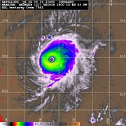 Multicolored satellite image of hurricane, with a clear eye at its center.