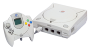 An NTSC Sega Dreamcast Console and PAL Controller with VMU.