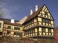 Large three-storied, half-timbered house, with plaster filling.