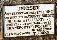 Sign headed "DORSET" and saying "Any person willfully INJURING any part of this COUNTY BRIDGE will be guilty of FELONY and upon conviction liable to be TRANSPORTED FOR LIFE by the court".