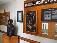 A bust of Edson next to a display of his medals and photographs