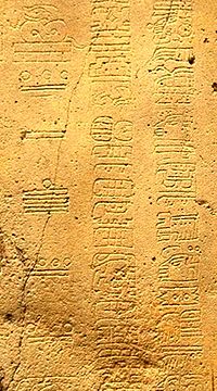 an inscription in Mayan characters set into yellow stone