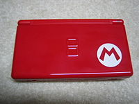 A red, dual-screen device pictured closed; in the corner is a red M inside of a white circle.